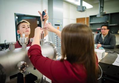 Physics professor and students working in a lab.